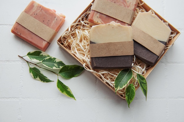 Assorted handmade soap bars and green leaves