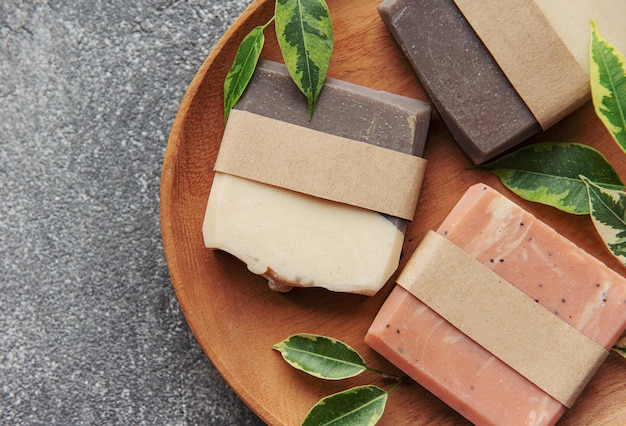 Assorted handmade soap bars and green leaves