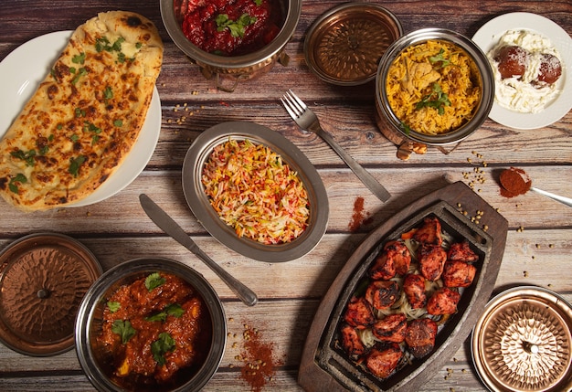 Assorted Indian dishes of rice and curry on wooden wall. Top view