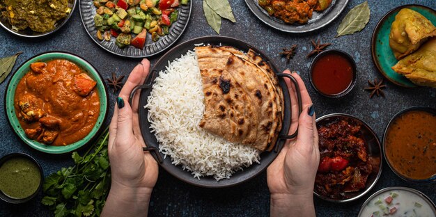 Assorted Indian ethnic food buffet on rustic concrete table from above