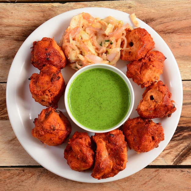 Assorted indian food chicken tikka kebab served on rustic\
wooden background dishes and appetizers of indian cuisine selective\
focus