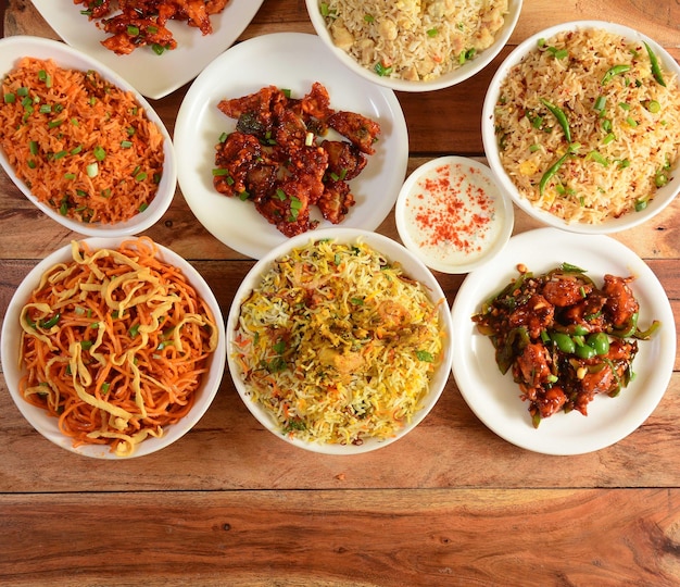 Assorted indian foods dragon chickenchicken biryanichicken
fried riceveg noodles and garlic chicken on wooden background
dishes and appetizers of indian cuisine