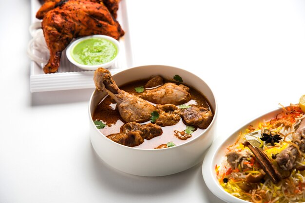 Ricetta alimentare indiana non vegetariana assortita servita in un gruppo. include pollo al curry, montone masala, anda o curry all'uovo, pollo al burro, biryani, tandoori murg, pollo-tikka e naa, roti per il ramadan