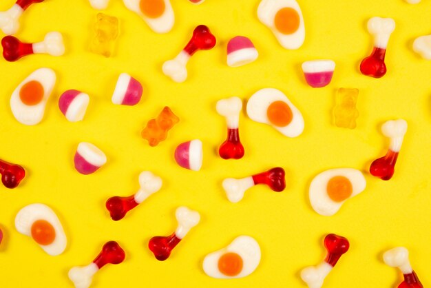 Assorted jelly sweets on yellow background