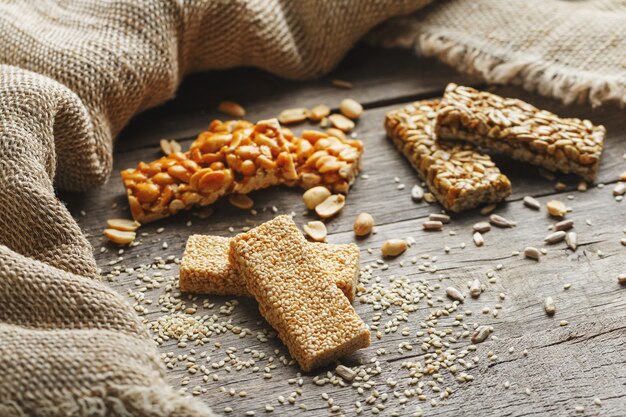 Assorted kozinaki,, with burlap fabric. Country style. Delicious sweets from the seeds of sunflower, sesame and peanuts, covered with shiny glaze.