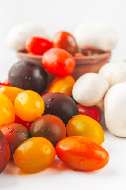 Photo assorted of marinated cherry tomatoes and mushrooms on white background