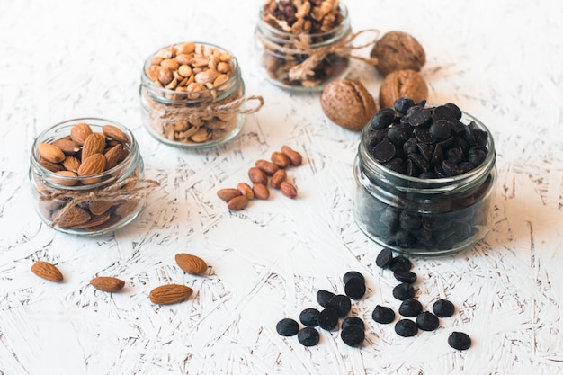 Assorted nuts in glass jars on gray background