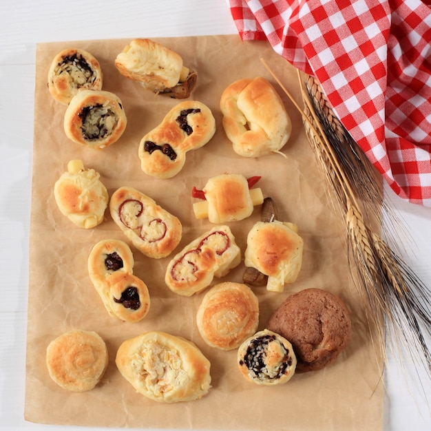 Assorted One Bites Mini Bread or Popular as Roti Unyil Venus on White Plate, White Background. Served for Accompanied Tea. Copy Space for Text