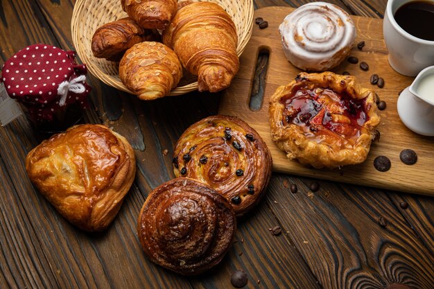 Assorted pastries croissants buns On a brown wooden table