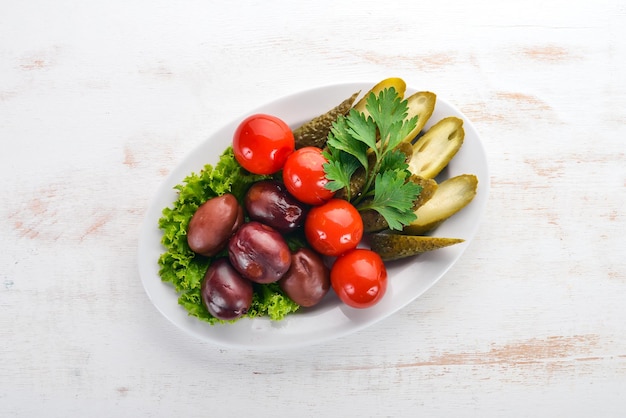 Assorted pickled vegetables on a plate On the old wooden background Free space for text Top view