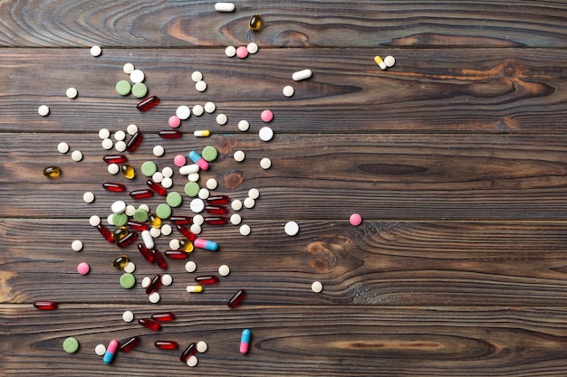 色付きの背景の上のさまざまな錠剤や錠剤の上部の境界線カラフルな背景の上面図のテキストのための多くの異なる錠剤とスペース