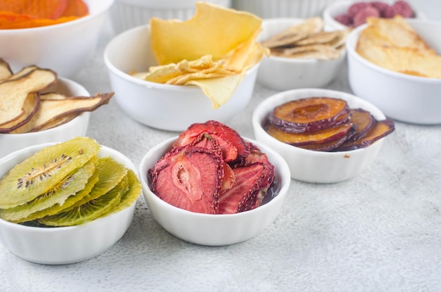 Assorted ripe fruits and dried chips on grey background