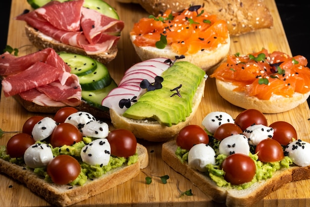 Assorted sandwiches with fish, cheese, meat and vegetables lying on the board