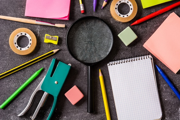 Photo assorted of school supplies on black slate back to school concept