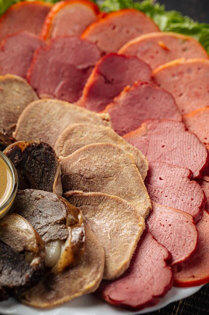 Photo assorted sliced smoked meat platter appetizer