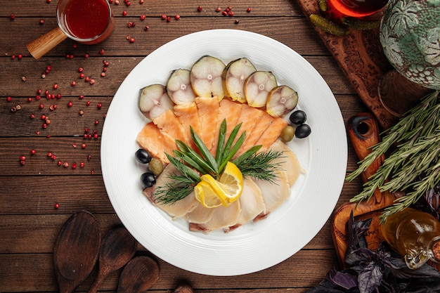 Assorted smoked fish platter on wooden background