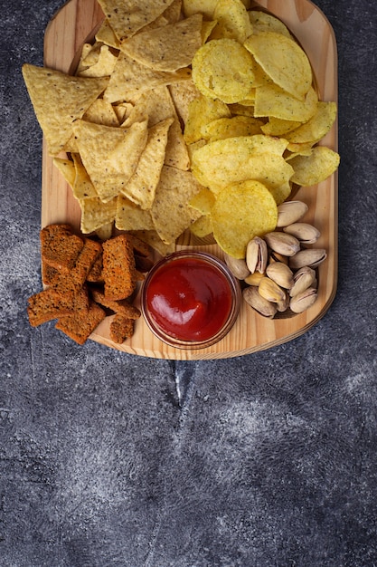 Assorted of snack. Chips, pistachios, nachos and peanuts. Selective focus