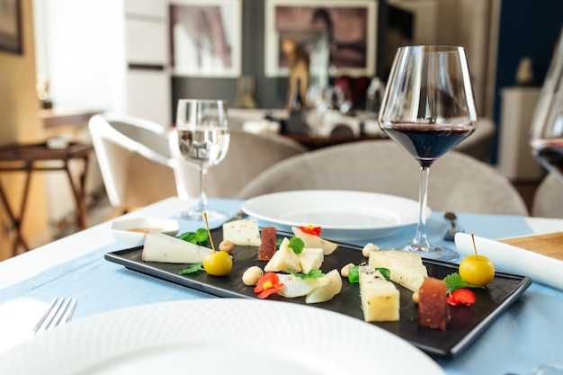 Assorted spanish cheese platter with red wine on the blue table