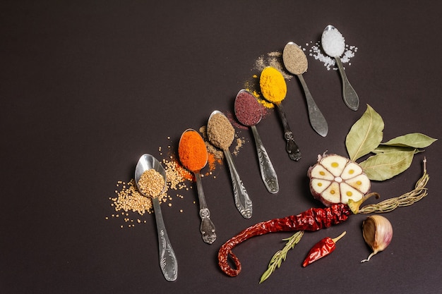 Assorted spices in spoons, dry herbs and vegetables