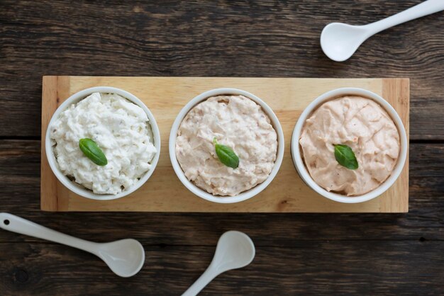 Assorted spread sandwich pasta and vegetarian spreads in white containers on a wooden table diet food top view