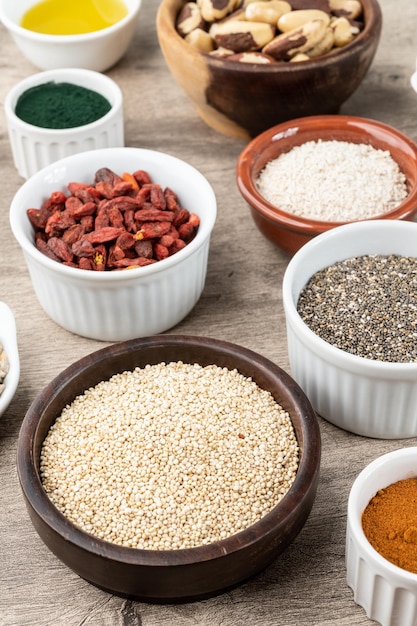 assorted superfoods in over wooden background chia quinoa oat linseed honey spirulina and others