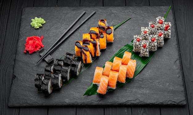 Assorted sushi nigiri and maki big set on slate A variety of Japanese sushi with tuna crab salmon eel and rolls