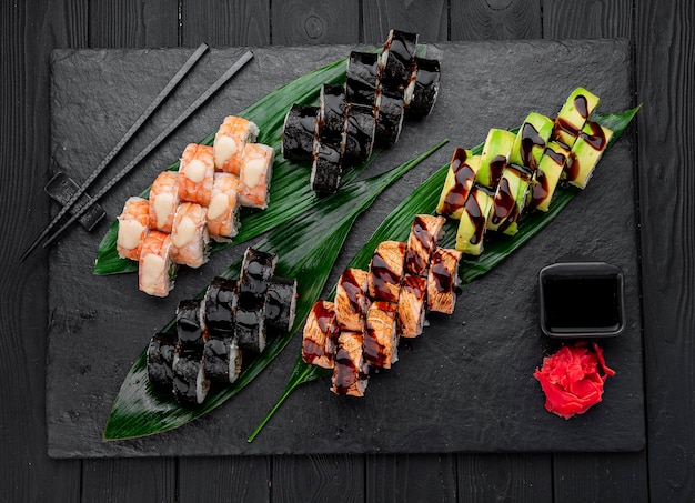 Nigiri di sushi assortiti e grande set di maki su ardesia una varietà di sushi giapponese con anguilla di salmone granchio tonno e involtini