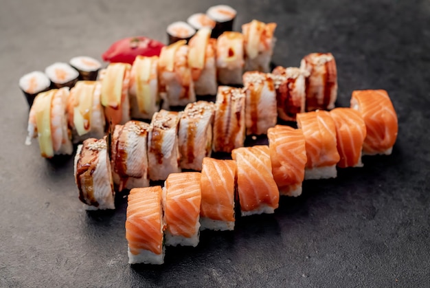 Assorted sushi set nigiri and sushi rolls on stone background