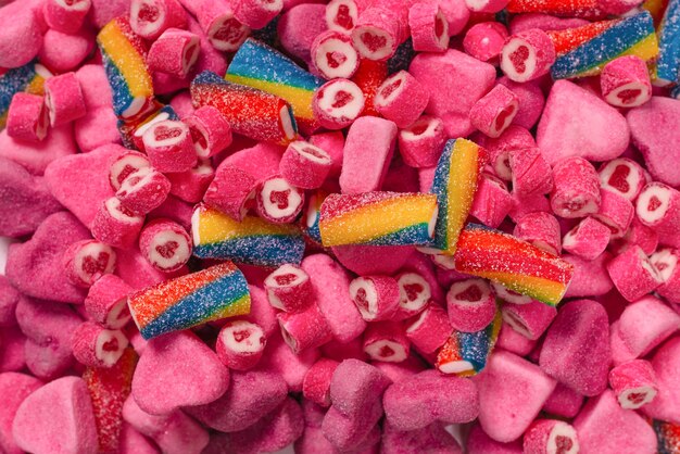 Assorted tasty gummy candies. Top view. Pink jelly sweets background.