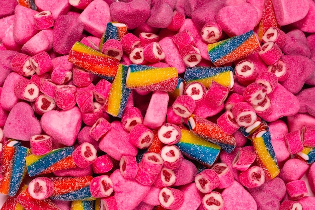 Assorted tasty gummy candies. Top view. Pink jelly sweets background.