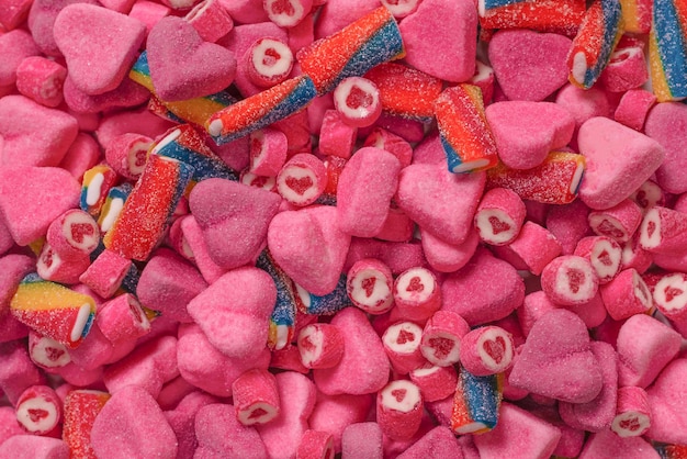 Assorted tasty gummy candies. Top view. Pink jelly sweets background.