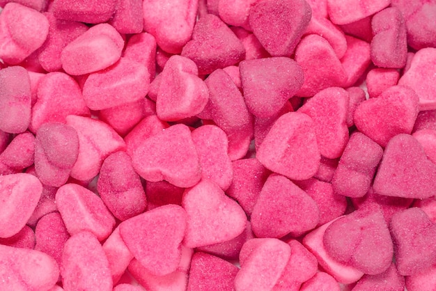 Assorted tasty gummy candies. Top view. Pink jelly sweets background.