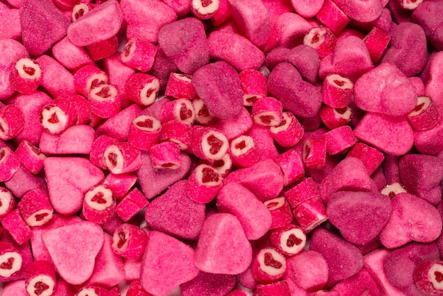 Assorted tasty gummy candies. Top view. Pink jelly sweets background.