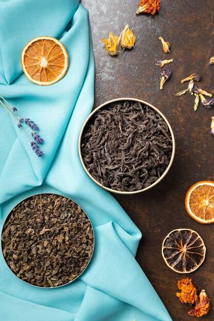 Photo assorted tea and citrus chips on a dark background top view