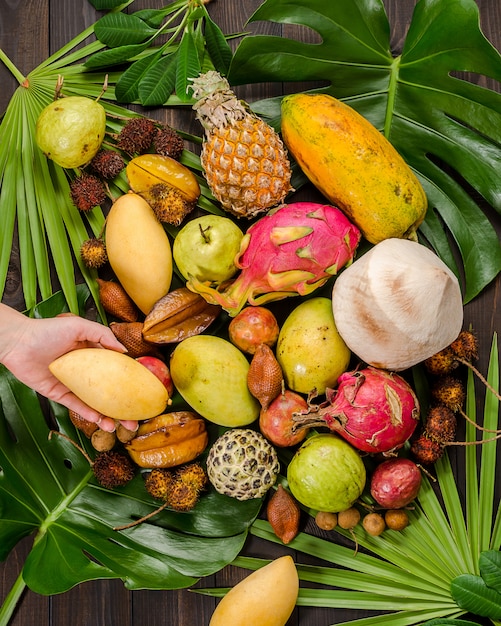 Assorted Thai tropical fruits on a dark wooden rustic background.