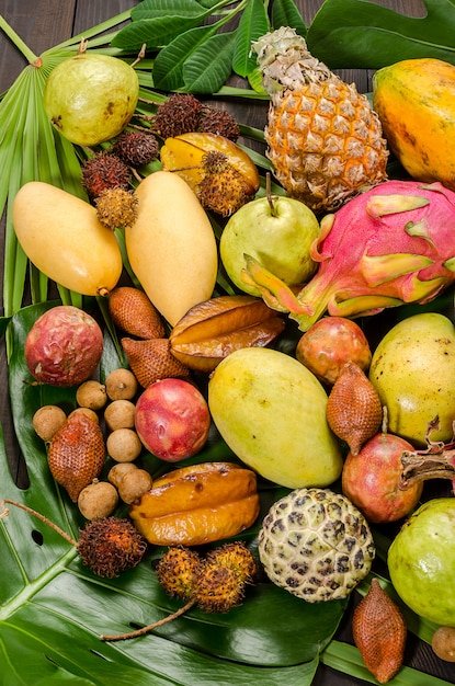 Assorted Thai tropical fruits on a dark wooden rustic background.