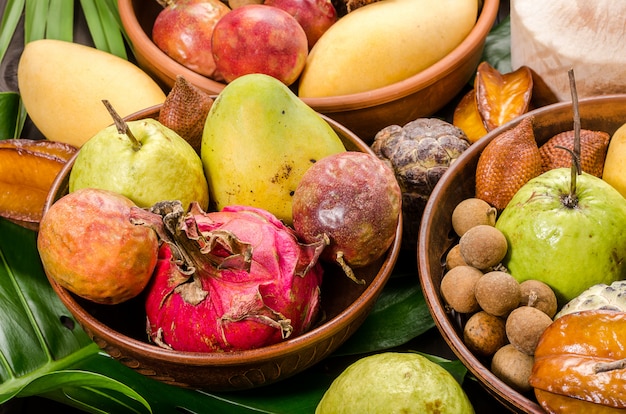 Assorted Thai tropical fruits on a dark wooden rustic background.