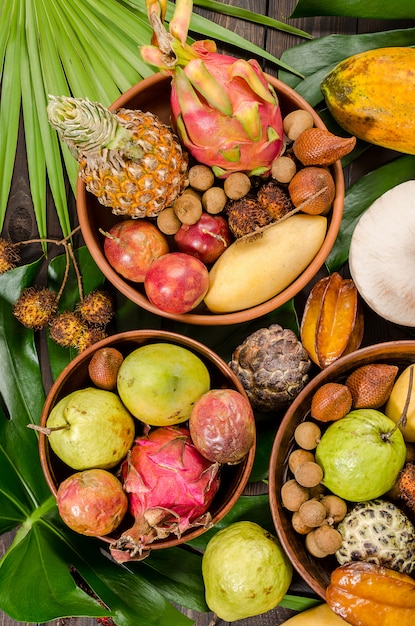 Photo assorted thai tropical fruits on a dark wooden rustic background.