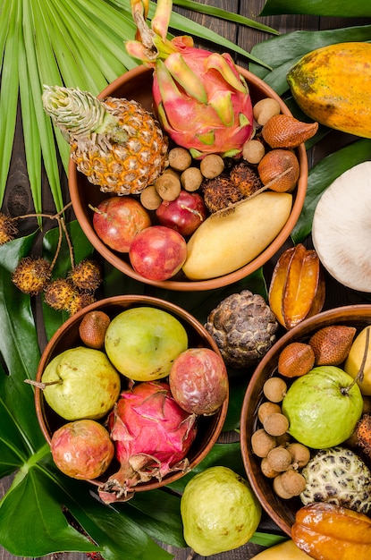 Assorted Thai tropical fruits on a dark wooden rustic background.