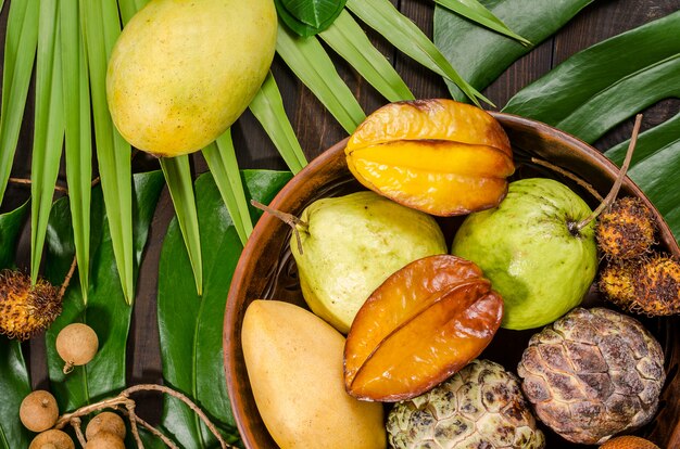 Assorted Thai tropical fruits on a dark wooden rustic background.