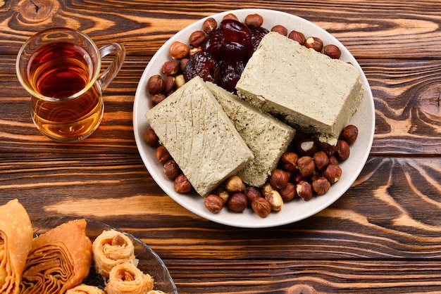 木製の背景にお茶と伝統的な東部のデザートの盛り合わせ。木製のテーブルにアラビアのお菓子。