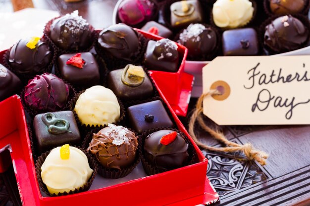 Photo assorted truffles in gift boxes for fathers day.