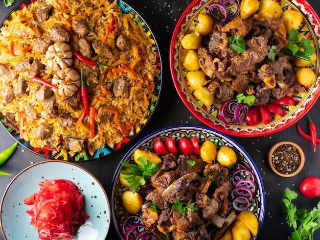 Photo assorted uzbek food set, pilaf, samsa, lagman, manta and korean carrots, uzbek restaurant concept, uzbek food feast