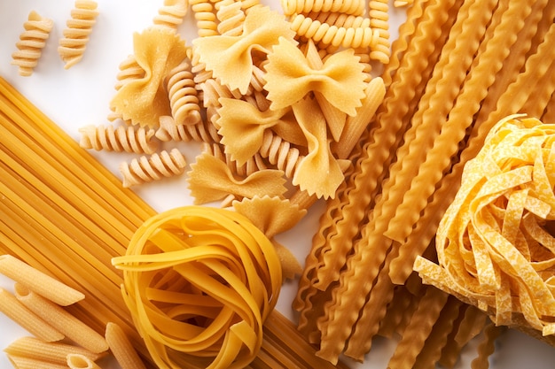 Assorted varieties of pasta wallpaper. Mix macaroni, spaghetti on white background