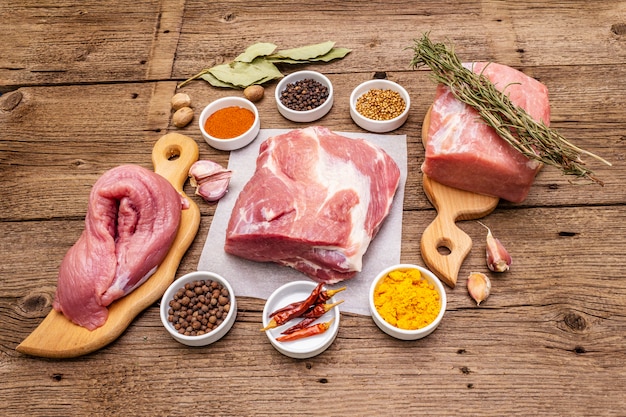 Assorted various fresh pork cuts. Raw meat with spices. Tenderloin, shoulder blade, neck