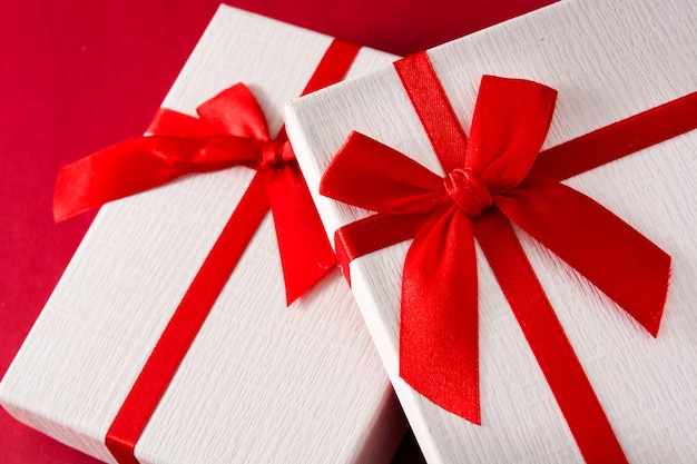 Assorted white gift boxes on red background close up