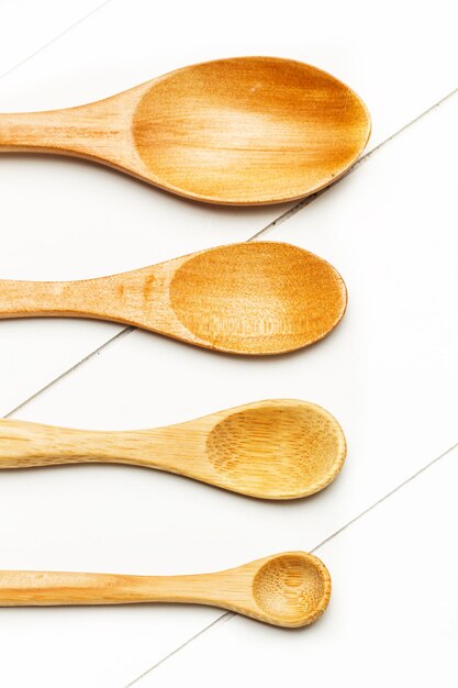 Assorted wooden spoons on a white wooden table