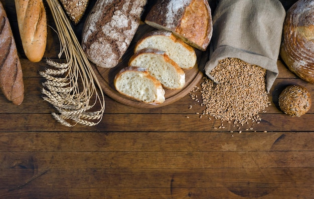 Assortiment broodproducten oren en tarwekorrels op houten tafel