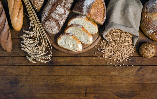 Assortiment broodproducten oren en tarwekorrels op houten tafel