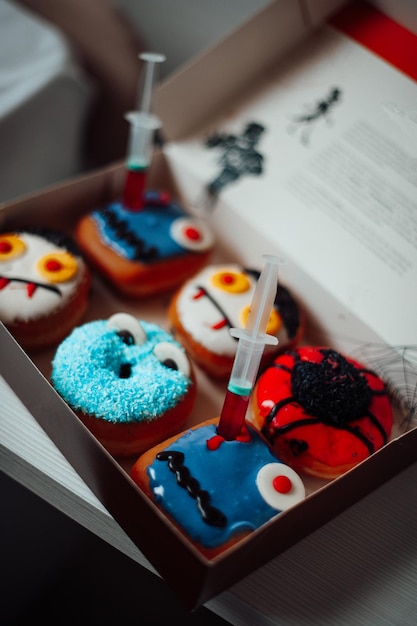 Assortiment halloween monsters met grappige gezichten donuts in doos thuis interieur